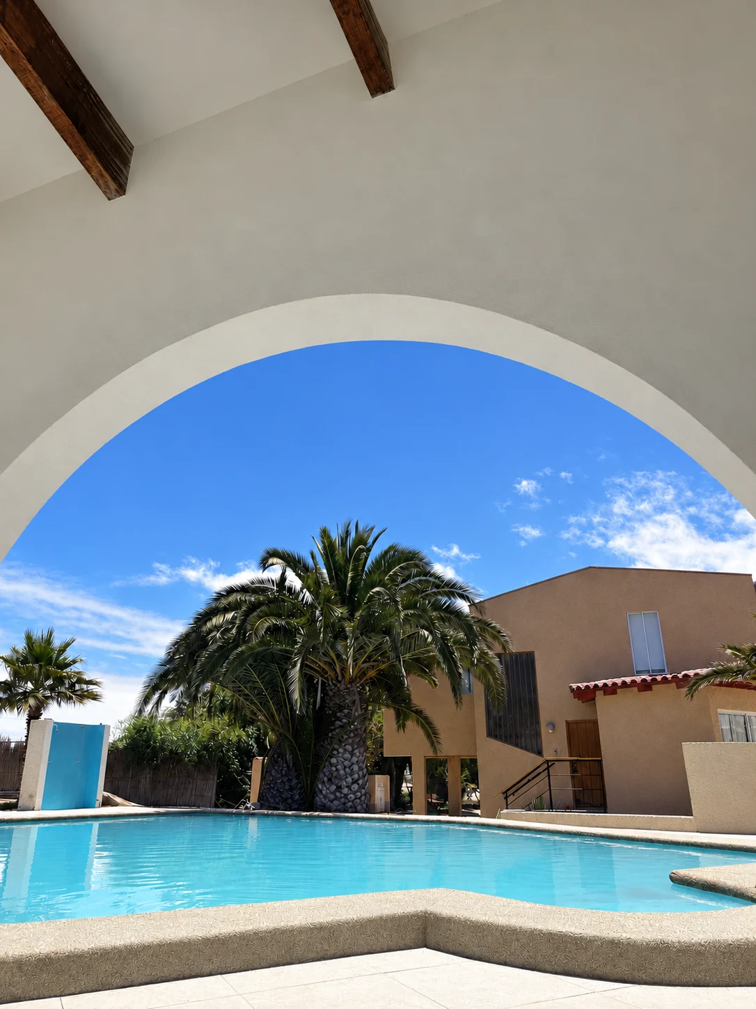 Piscina y patio de Playa Blanca bajo una arquería blanca